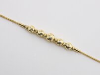 Zlatý náramok so žltými guľôčkami