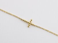 Zlatý náramok s krížikom a čiernymi guľôčkami