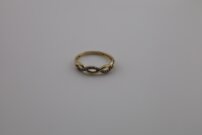 Elegantný zlatý prsteň s prepleteným a trblietavými kamienkami,